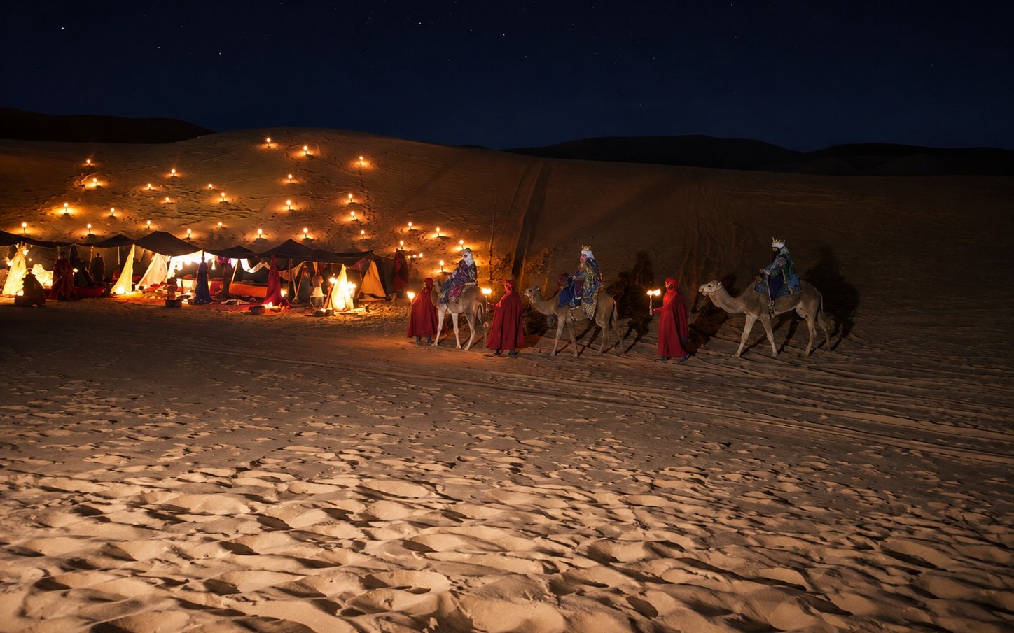 The Three Kings' camp lit by hundreds of candles on the dune